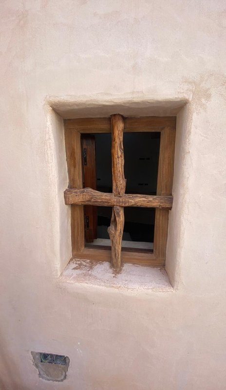 Ventana nueva de madera sobre muro tradicional